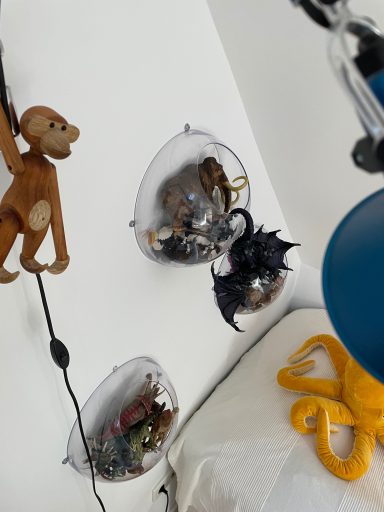 Schwebende Behälter mit Spielzeugen, darunter ein Affe, ein Drache und ein Tintenfisch.